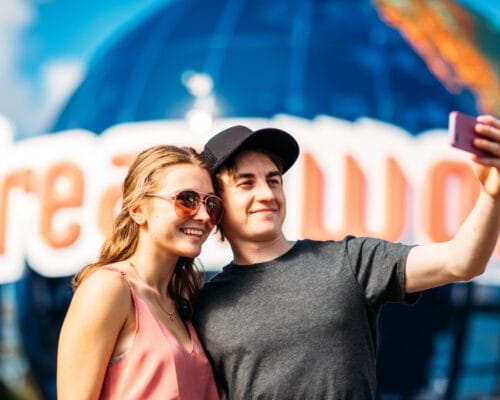 couple-taking-photo-on-phone-in-front-of-dreamworld-sign